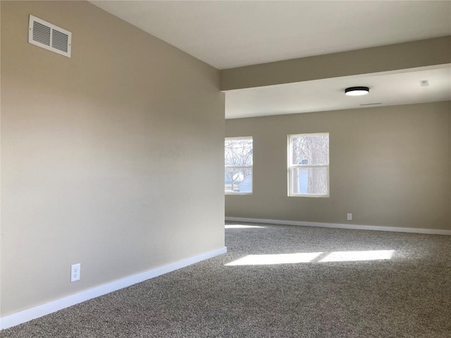 carpeted empty room featuring visible vents and baseboards