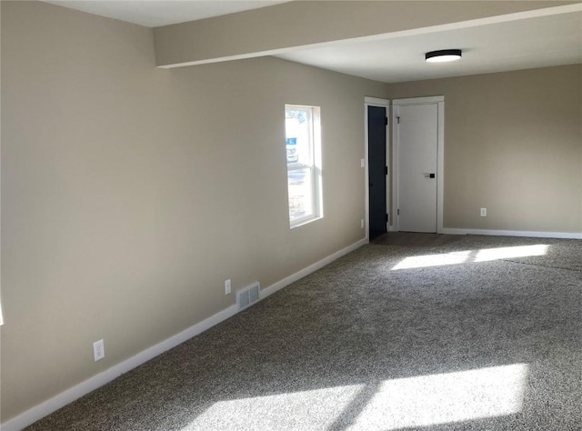 carpeted spare room with visible vents and baseboards