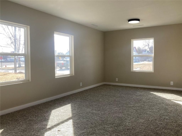 empty room featuring carpet and baseboards