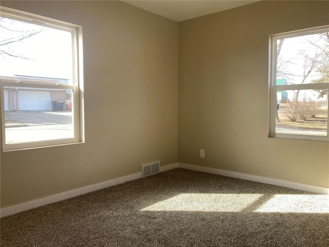 carpeted spare room with visible vents and baseboards