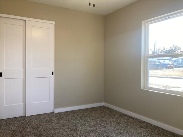 208 G Ave, Vinton, IA 52349 - unfurnished bedroom with carpet flooring, baseboards, and a closet