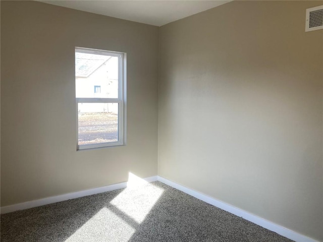 empty room with carpet floors, baseboards, and visible vents