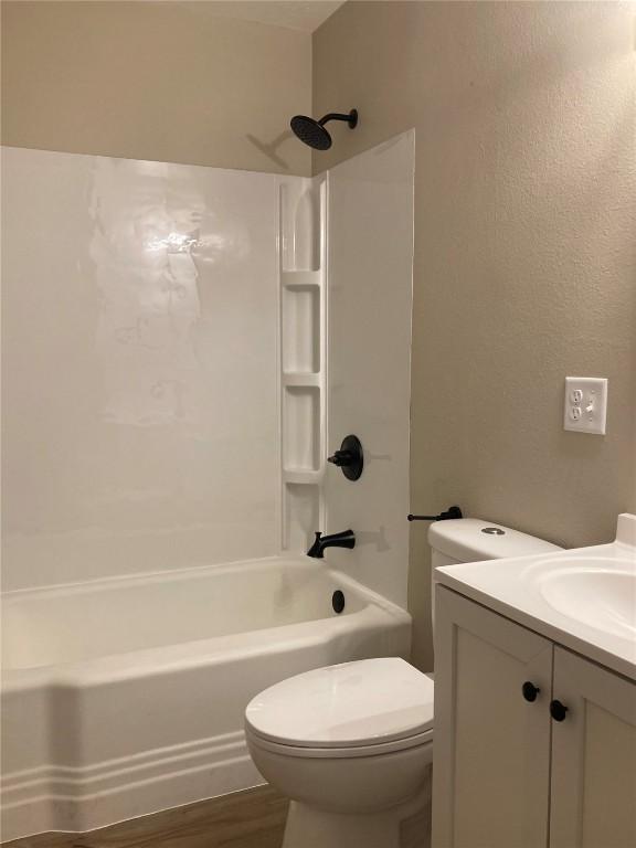 208 G Ave, Vinton, IA 52349 - bathroom with shower / washtub combination, toilet, vanity, and wood finished floors