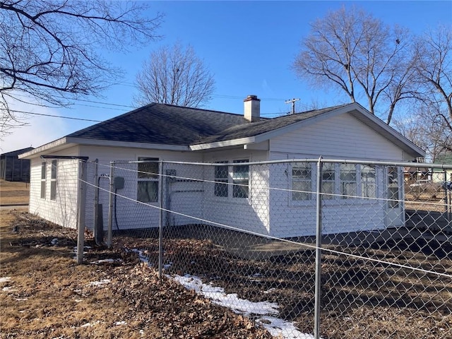 view of property exterior featuring roof with shingles, fence, and a chimney