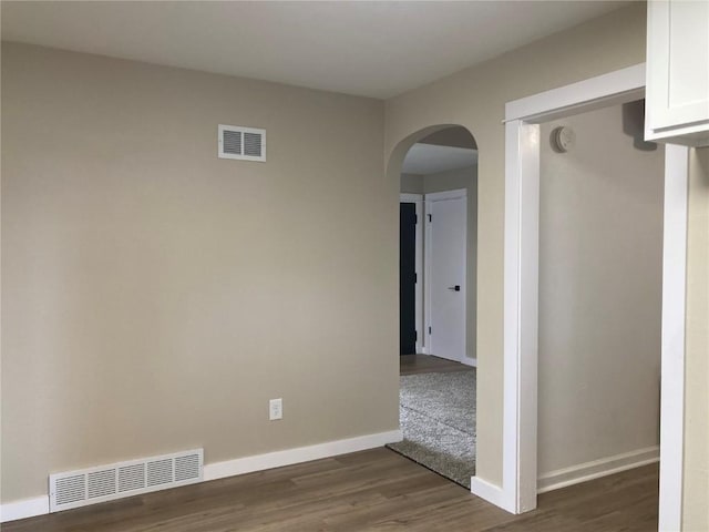 208 G Ave, Vinton, IA 52349 - unfurnished room featuring arched walkways, dark wood-style floors, baseboards, and a smoke detector