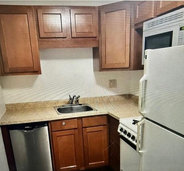 kitchen featuring light countertops, white appliances, a sink, and decorative backsplash