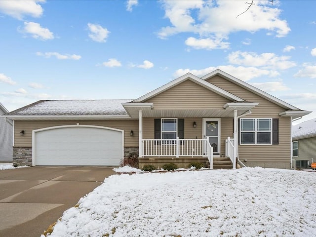 view of front of home with stone siding, driveway, a porch, and an attached garage