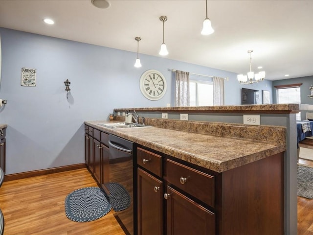 kitchen with a peninsula, dishwasher, light wood-style floors, and a sink