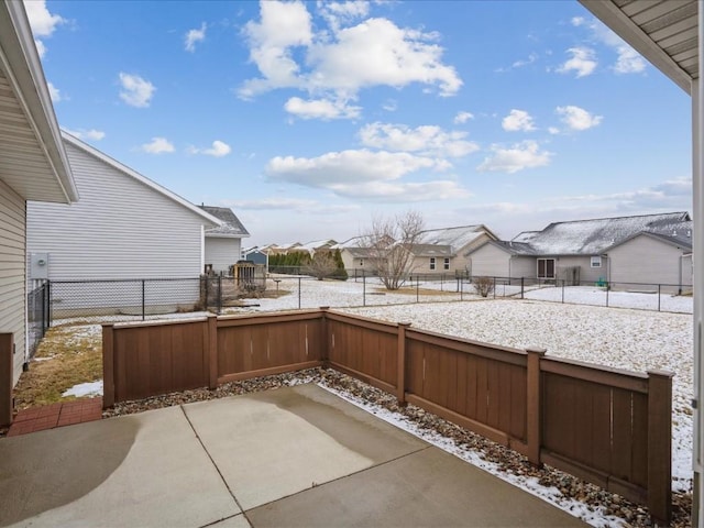 snow covered patio with a residential view and a fenced backyard