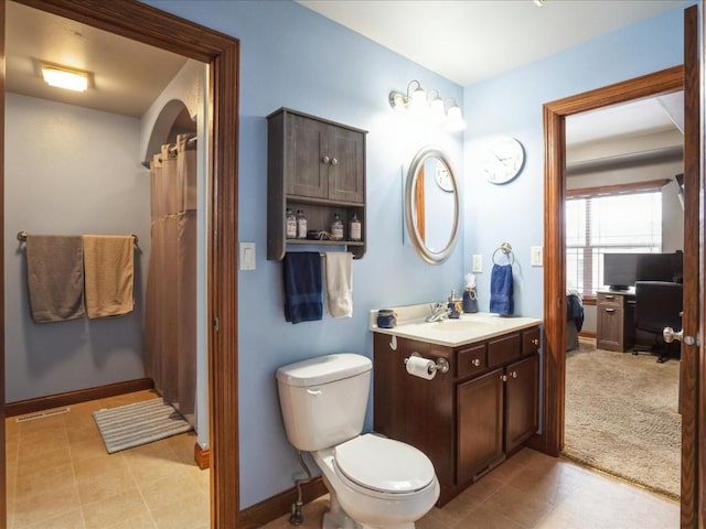 full bathroom with baseboards, toilet, and vanity