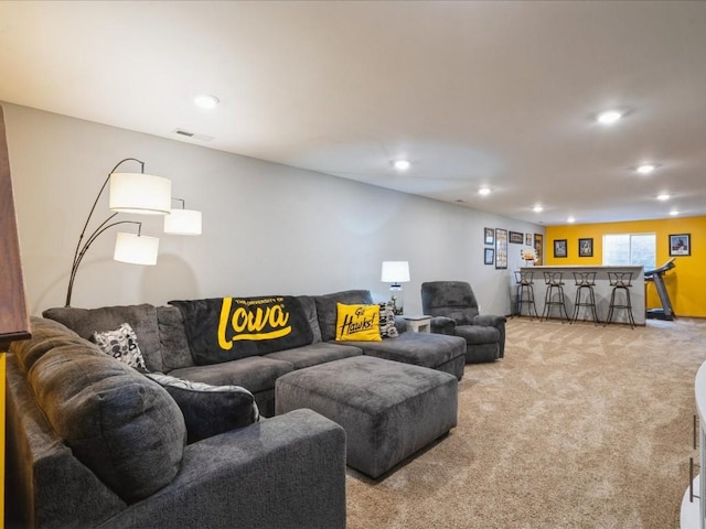 living room featuring recessed lighting, visible vents, light colored carpet, and a dry bar