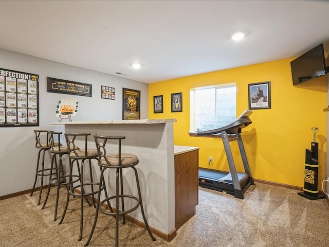 bar featuring baseboards, recessed lighting, a bar, and carpet