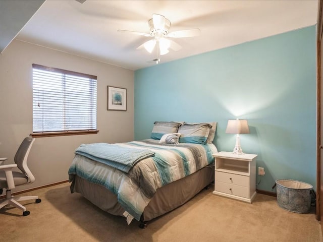 bedroom with a ceiling fan, baseboards, and light carpet