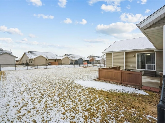 yard covered in snow with fence and a residential view