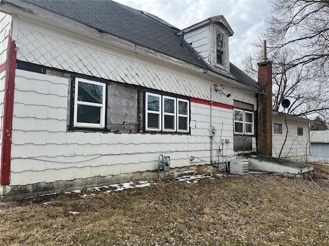 view of home's exterior with a shingled roof and central air condition unit