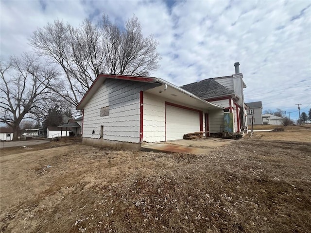 view of property exterior with a garage and a chimney