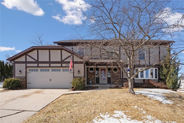 view of front of house featuring a garage, brick siding, driveway, and stucco siding