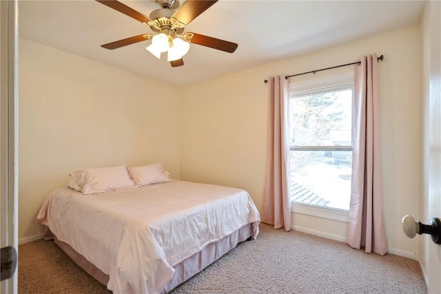 carpeted bedroom featuring baseboards and a ceiling fan