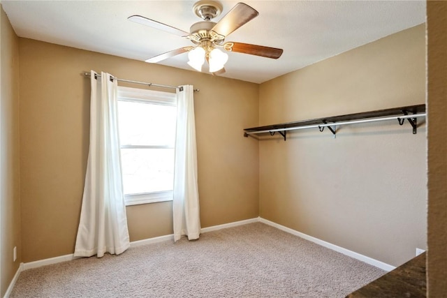 interior space featuring carpet floors, a ceiling fan, and baseboards