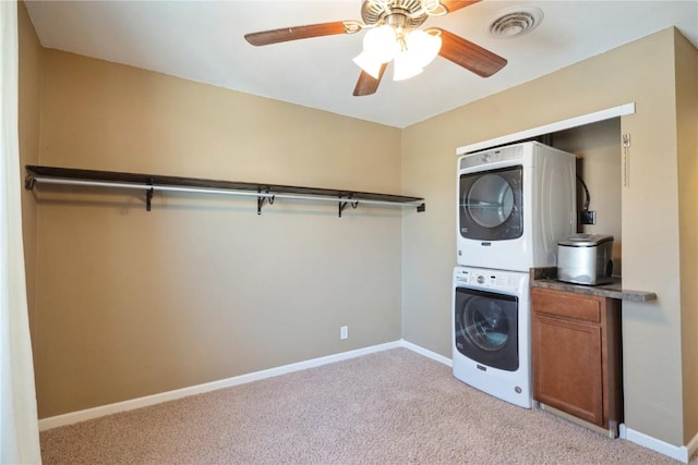 washroom with stacked washer and dryer, baseboards, cabinet space, and light colored carpet