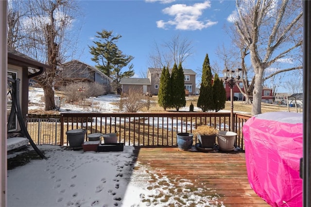 snow covered deck with a residential view and grilling area