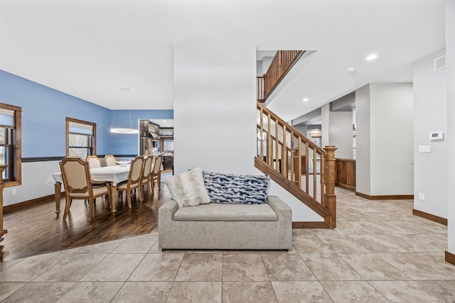 interior space featuring light tile patterned floors, visible vents, baseboards, and stairs