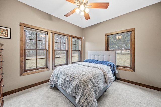 bedroom featuring a ceiling fan, light colored carpet, and baseboards