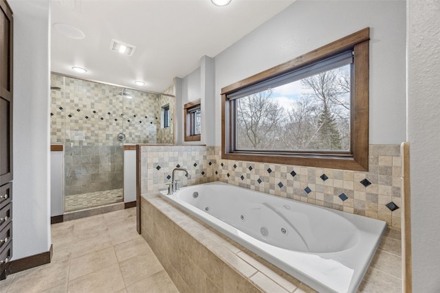 bathroom with tile patterned flooring, a jetted tub, visible vents, and walk in shower