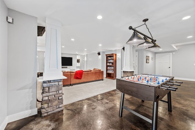 recreation room featuring baseboards, recessed lighting, finished concrete flooring, and ornate columns