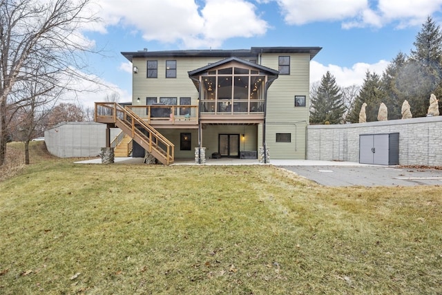 rear view of property featuring a patio, stairway, a yard, a sunroom, and a deck