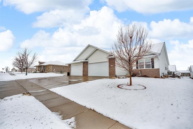 single story home with brick siding, cooling unit, and a garage