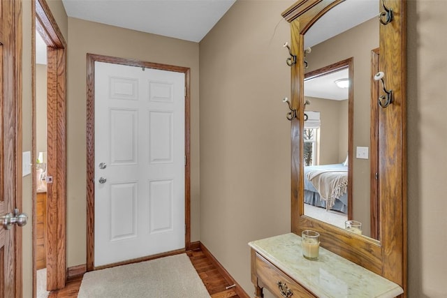 foyer featuring baseboards and wood finished floors