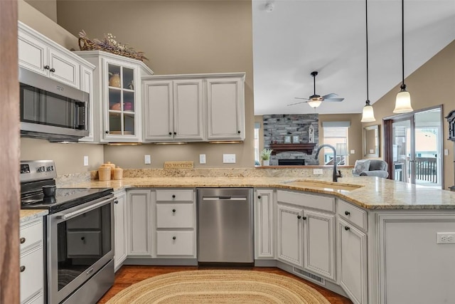 kitchen with visible vents, a sink, stainless steel appliances, a peninsula, and white cabinets