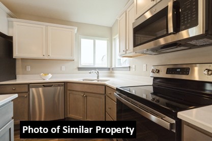 kitchen with a sink, light countertops, white cabinetry, and stainless steel appliances