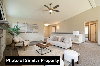 carpeted living room with vaulted ceiling, plenty of natural light, and ceiling fan