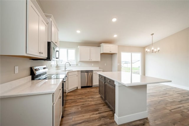 6166 Cope Dr, Marion, IA 52302 - kitchen featuring stainless steel appliances, wood finished floors, a sink, light countertops, and recessed lighting