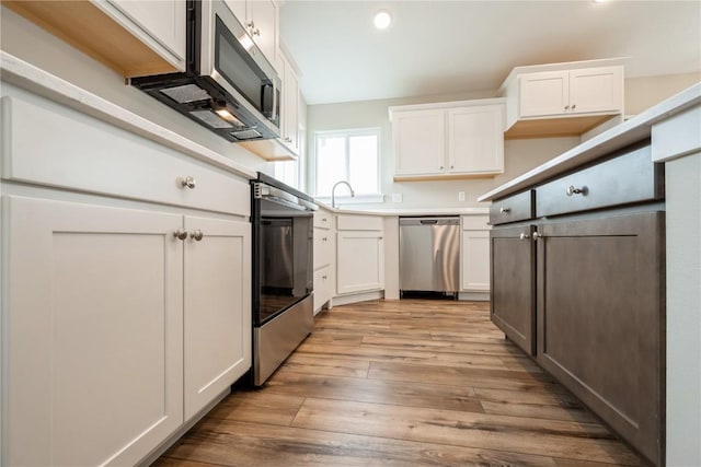 6166 Cope Dr, Marion, IA 52302 - kitchen featuring appliances with stainless steel finishes, white cabinetry, light wood-type flooring, recessed lighting, and light countertops
