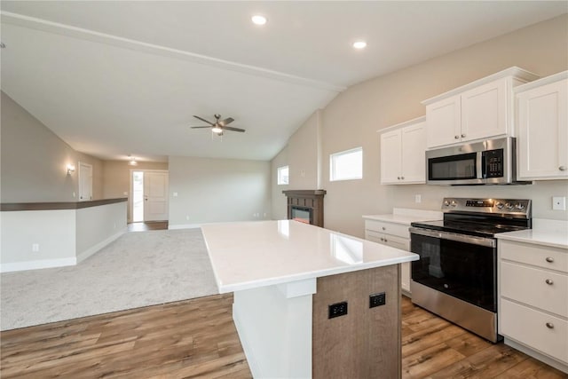 6166 Cope Dr, Marion, IA 52302 - kitchen with appliances with stainless steel finishes, light wood-type flooring, ceiling fan, a kitchen island, and white cabinets