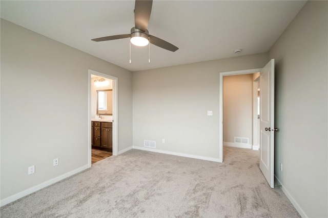 6166 Cope Dr, Marion, IA 52302 - unfurnished bedroom with light colored carpet, baseboards, connected bathroom, and a ceiling fan