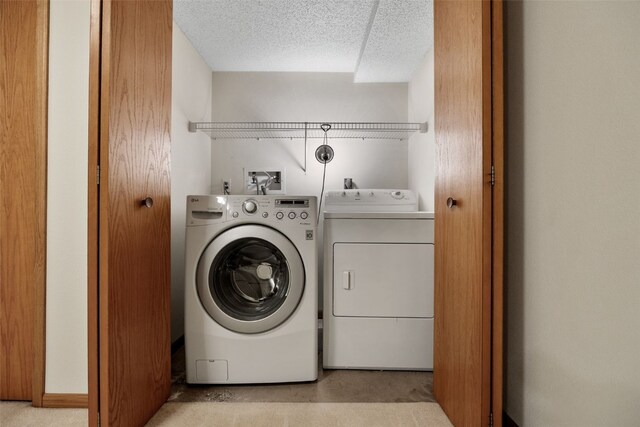 laundry room with a textured ceiling, laundry area, and washing machine and clothes dryer