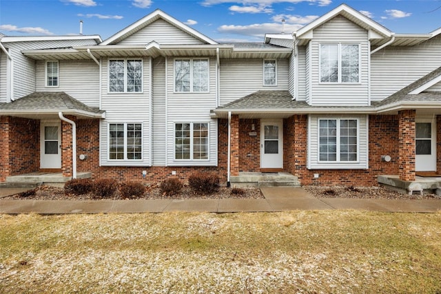 townhome / multi-family property featuring brick siding and a shingled roof