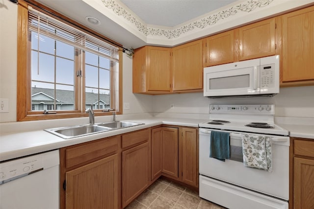 kitchen with a sink, white appliances, a textured ceiling, and light countertops