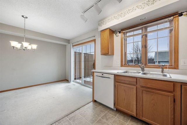 kitchen featuring light colored carpet, dishwasher, light countertops, a textured ceiling, and a sink