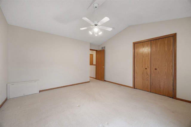 unfurnished bedroom featuring visible vents, baseboards, vaulted ceiling, carpet flooring, and a closet