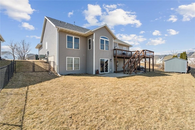 back of house featuring stairway, a wooden deck, a storage shed, a fenced backyard, and an outdoor structure