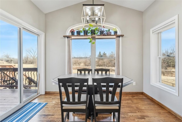 dining room with baseboards, plenty of natural light, and light wood-style floors