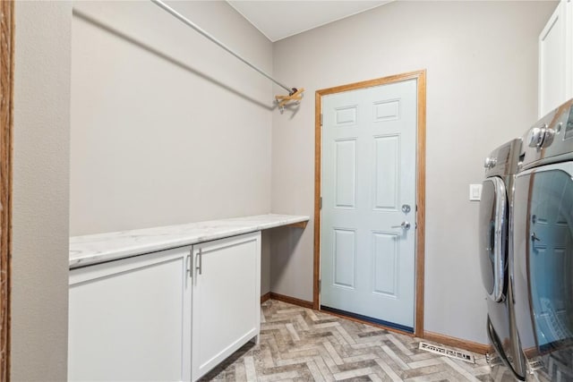 clothes washing area featuring baseboards, cabinet space, separate washer and dryer, and visible vents