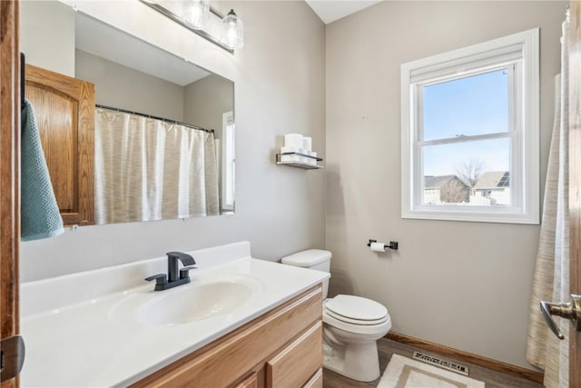 bathroom featuring vanity, toilet, baseboards, and visible vents