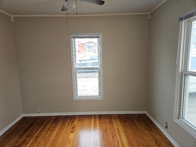 unfurnished room featuring a ceiling fan, crown molding, baseboards, and hardwood / wood-style flooring