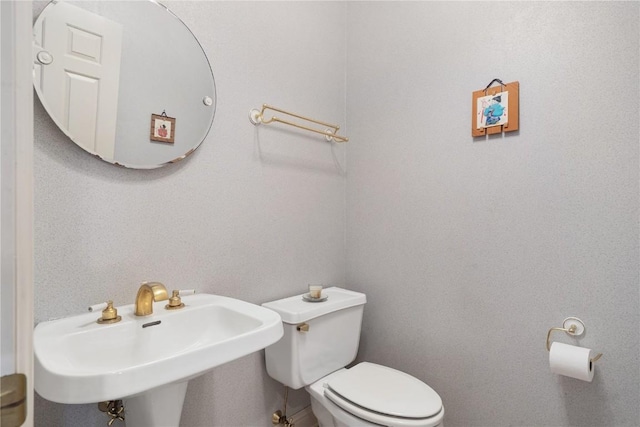 half bathroom featuring a sink and toilet